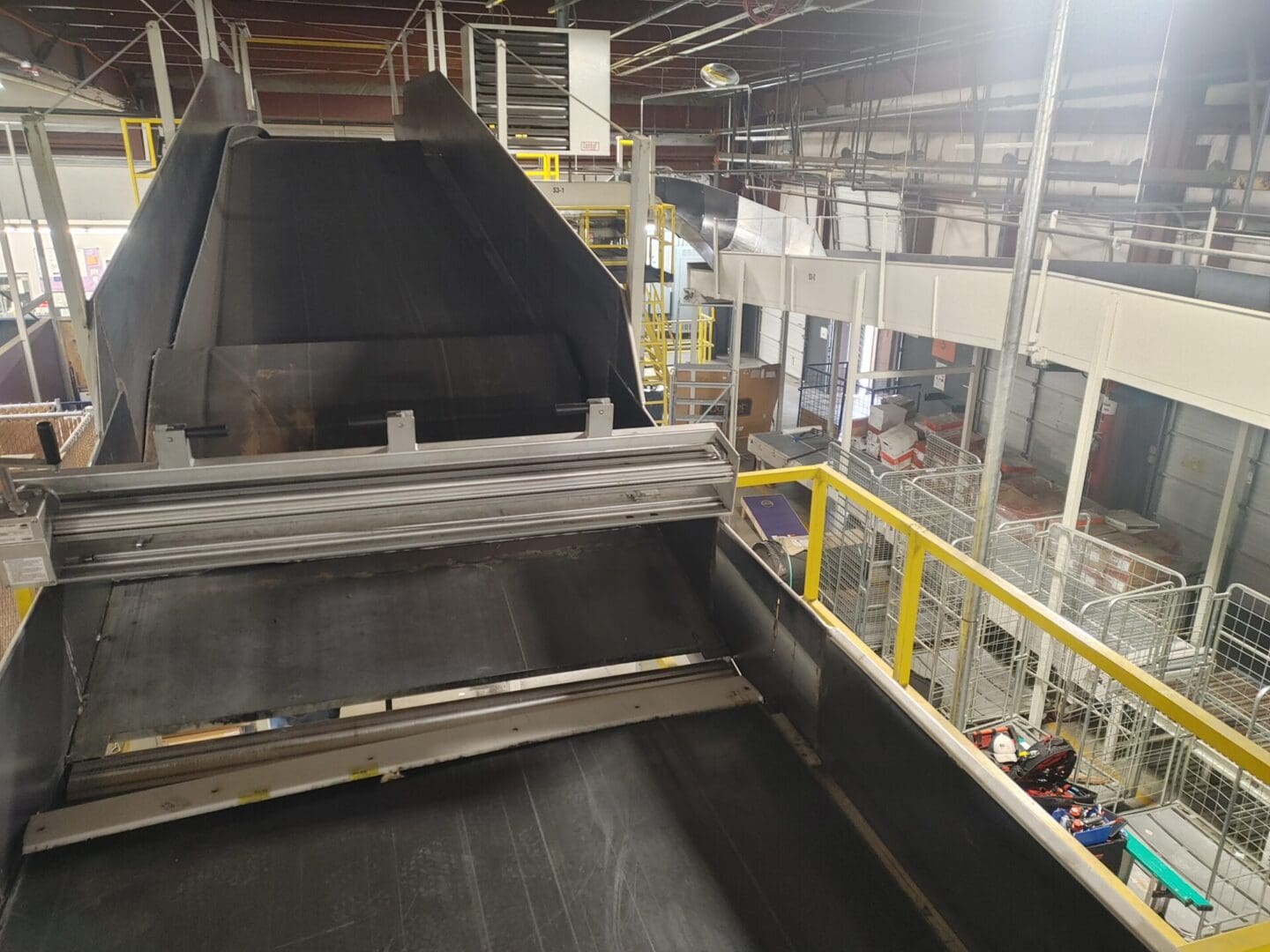 A conveyor belt in an industrial setting with people.